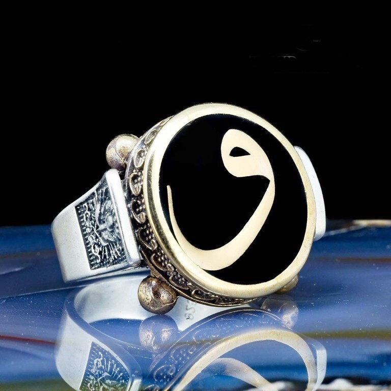 Round silver ring with the letter